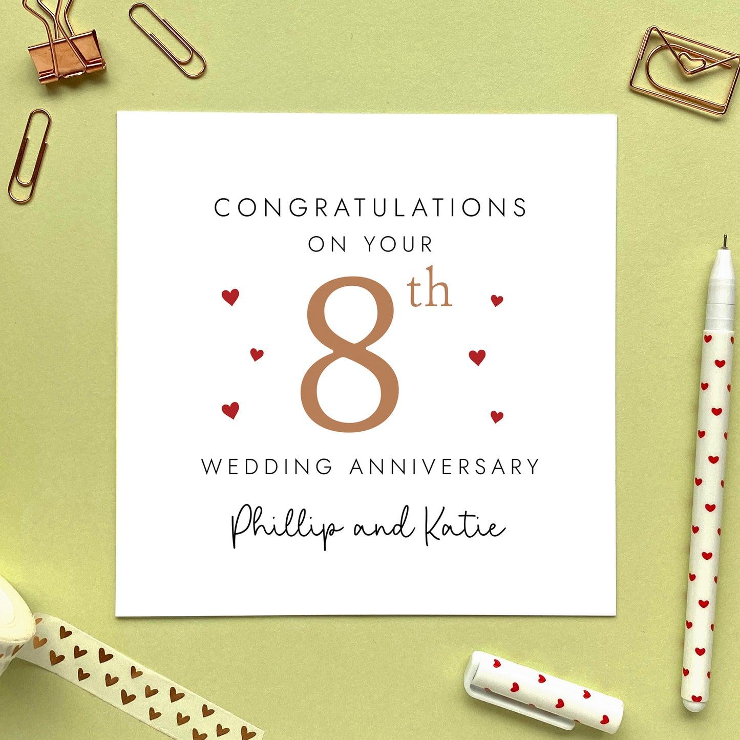 A personalised 8th wedding anniversary card for couple. It features '8th' in bronze brown with red hearts, the colour scheme matches the theme of bronze. The text reads 'Congratulations on your 8th wedding anniversary'. This card can be personalised with two names, and is suitable for special friends and family relations such as Daughter and Son-in-Law and Son and Daughter-in-Law. It is also suitable for gay and lesbian couples.