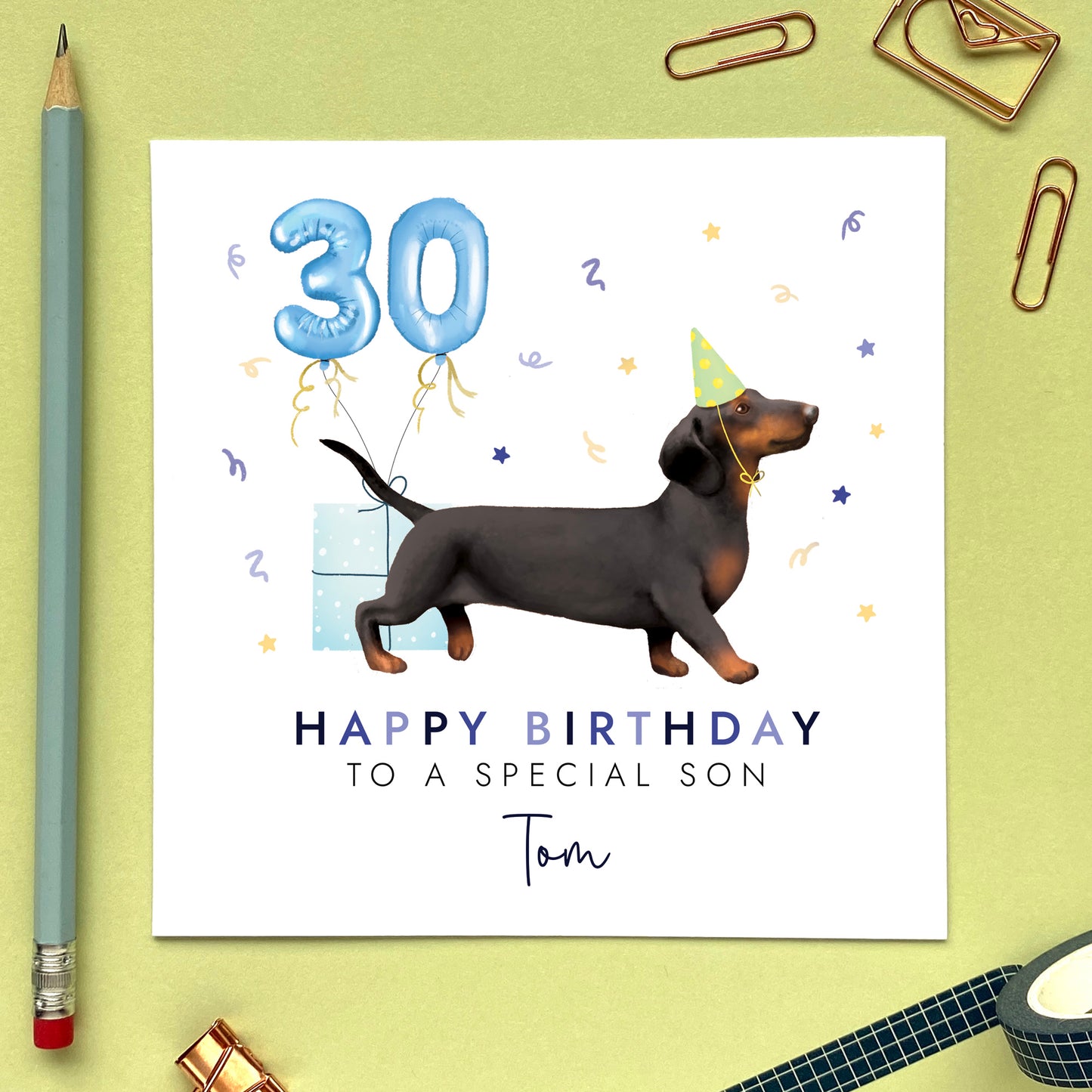 A personalised dog birthday card for him featuring a black and tan sausage dog (Dachshund). It can be personalised with any name and age. The card in the photo is a 30th birthday card for son.