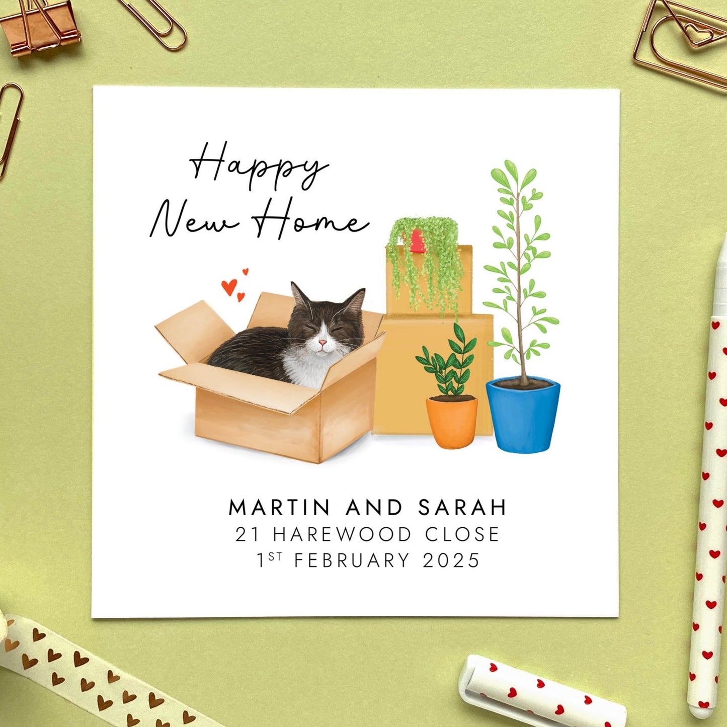 A personalised Happy New Home card featuring a black and white tuxedo cat in a box.