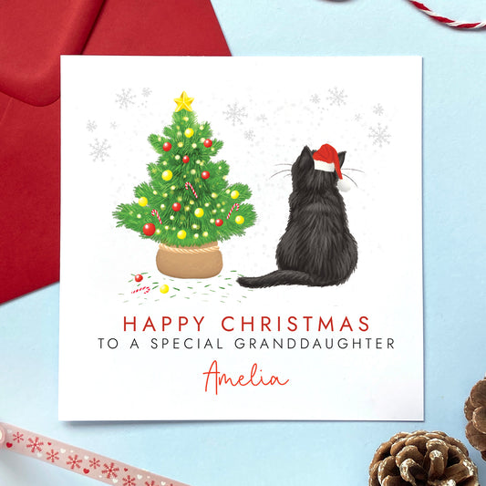A personalised cat christmas card. You can choose the cat on the design from a wide range of options, examples include ginger cat, black cat, ragdoll cat, tabby cat and grey cat. It can be personalised by adding a name and any relation. The card in the photo is a black cat christmas card for granddaughter.