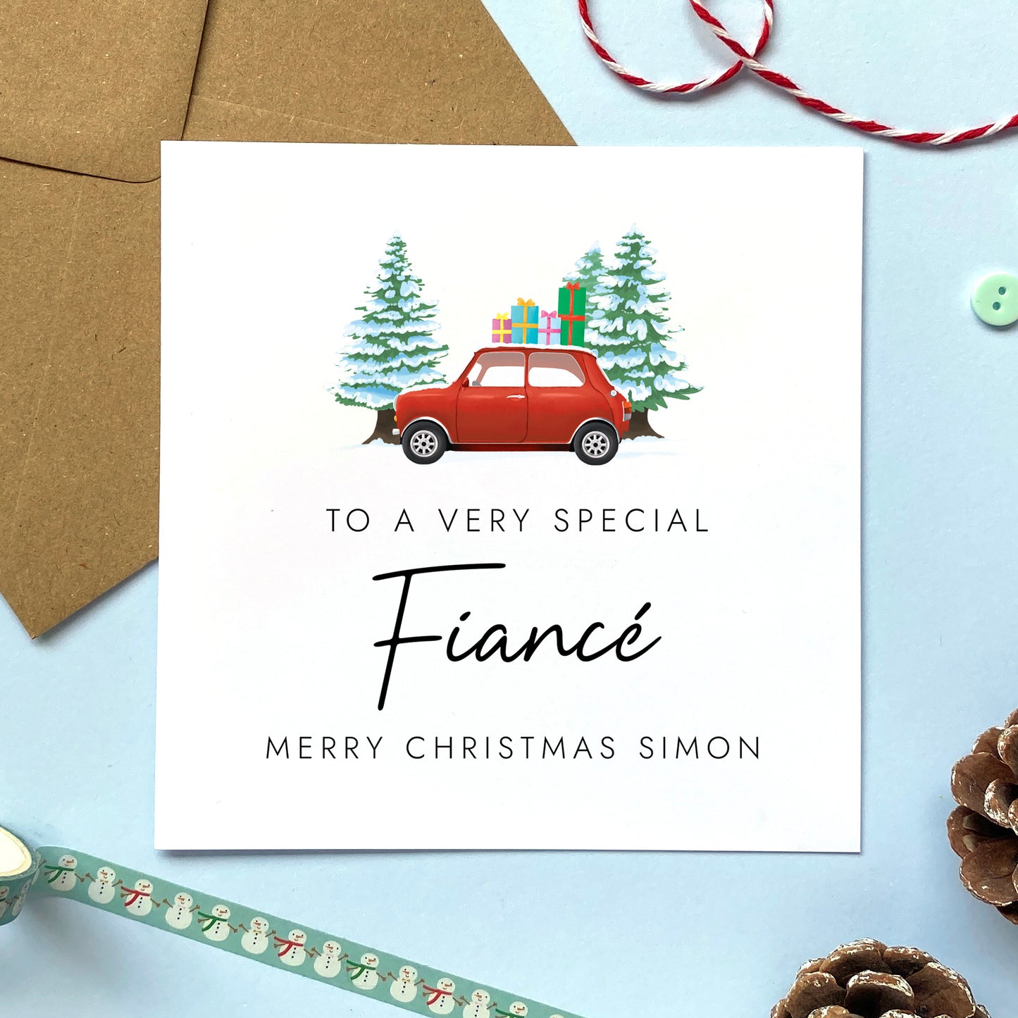 A personalised Christmas card for Fiance featuring a classic red mini car, presents and fir trees. It can be personalised with a name.