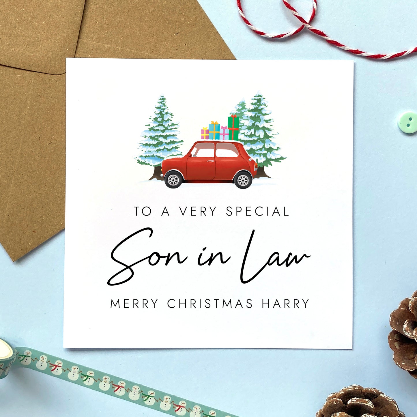 A personalised Christmas card for Son in Law featuring a classic red mini car, presents and fir trees. It can be personalised with a name.