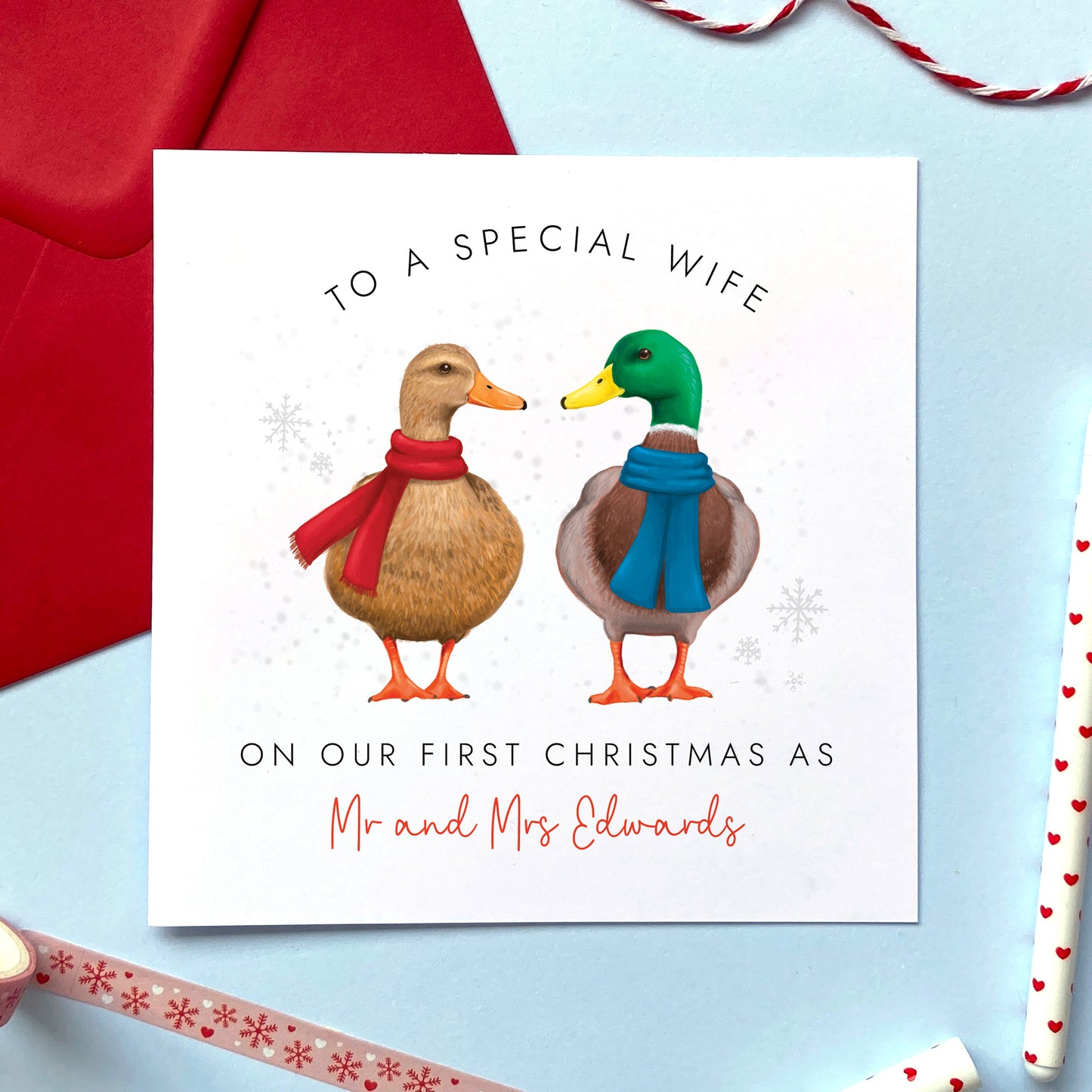 A personalised On Our First Christmas as Mr and Mrs Christmas card featuring a duck couple. It can be personalised with a surname, and is for couples who are celebrating 'our 1st christmas as a married couple'. The card in the photo is a Christmas Card for Husband.