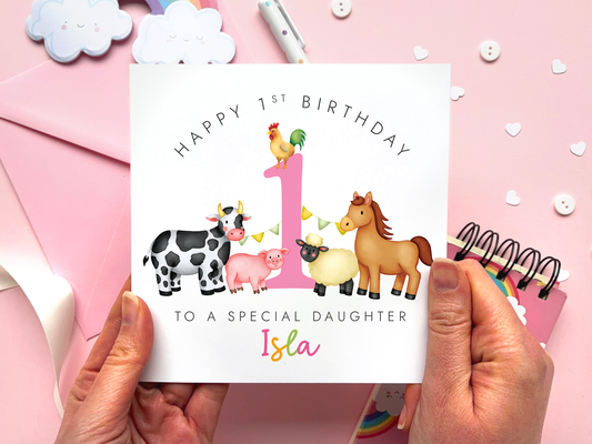 A bold and bright farm themed 1st birthday card for girls. It features a sheep, pig, cow, horse and chicken, around the number one. It can be personalised with the child's name.