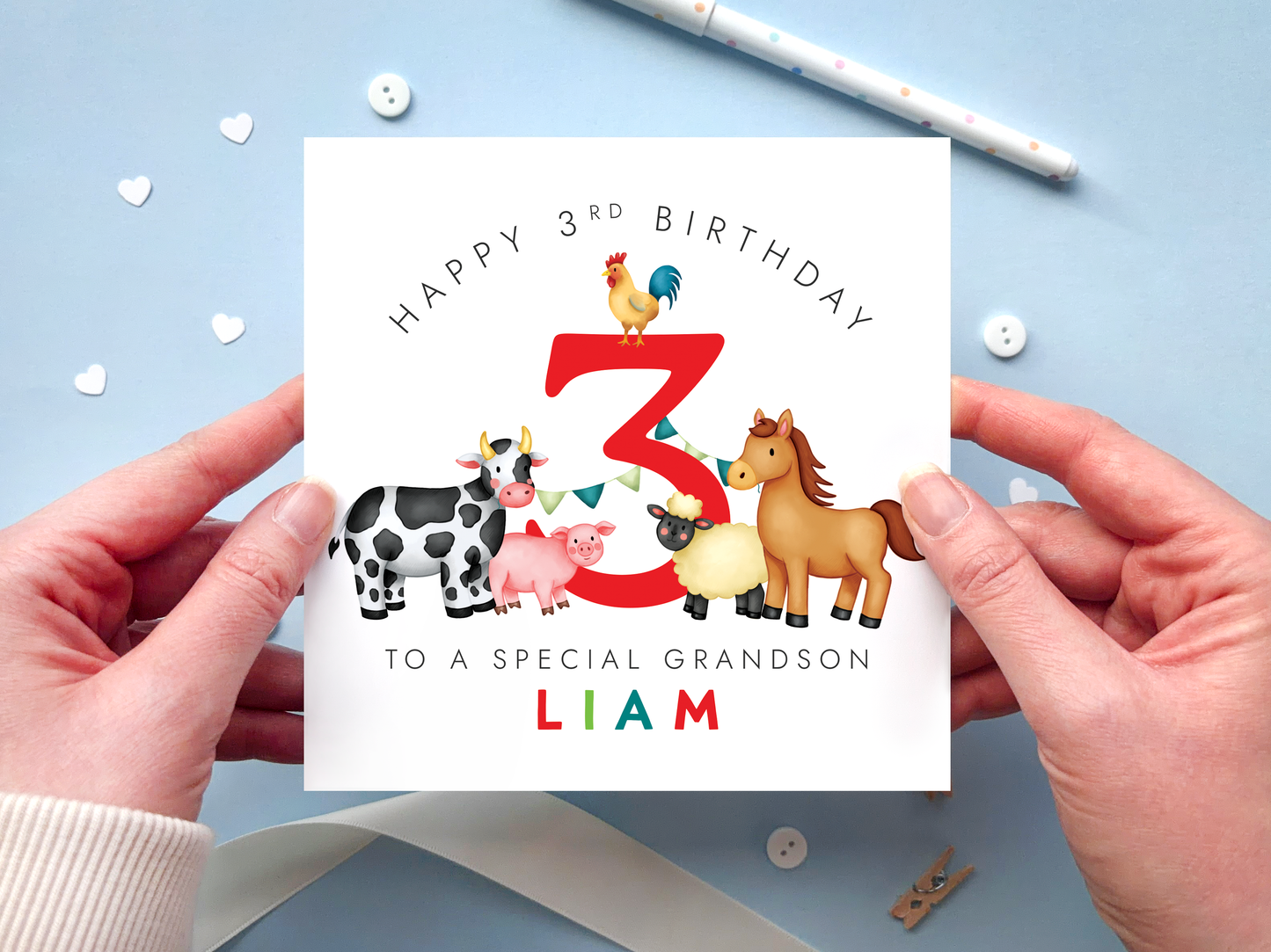 A bold and bright farm themed 3rd birthday card for boys. It features a sheep, pig, cow, horse and chicken, around the number three. It can be personalised with the child's name.