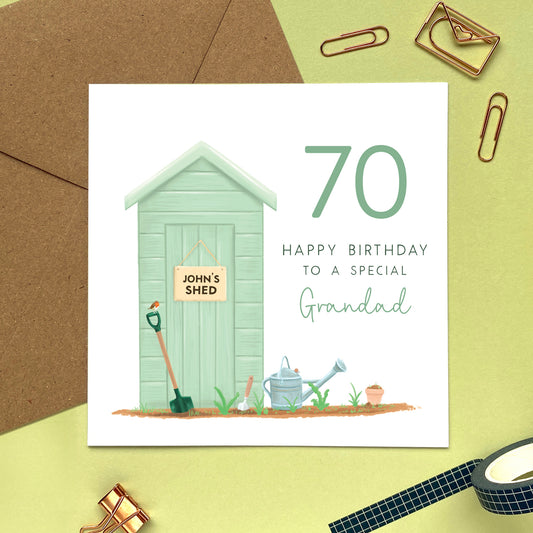 A personalised gardening themed birthday card for Grandfathers featuring a green garden shed. The shed's sign can be personalised with a name. It's suitable for any age including 60th, 70th, 80th and 90th birthdays. The relation can be changed to any male relation, such as Grandad, Grandpa, Great Grandad, Great Grandpa or Dad. The card in the photo is a 70th birthday card for Grandad.
