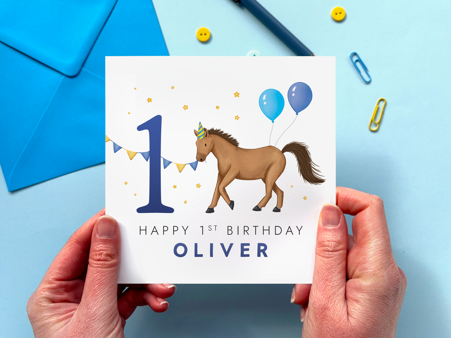 personalised 1st horse birthday card for boys featuring a handdrawn design with a brown horse and the number 1, with blue balloons