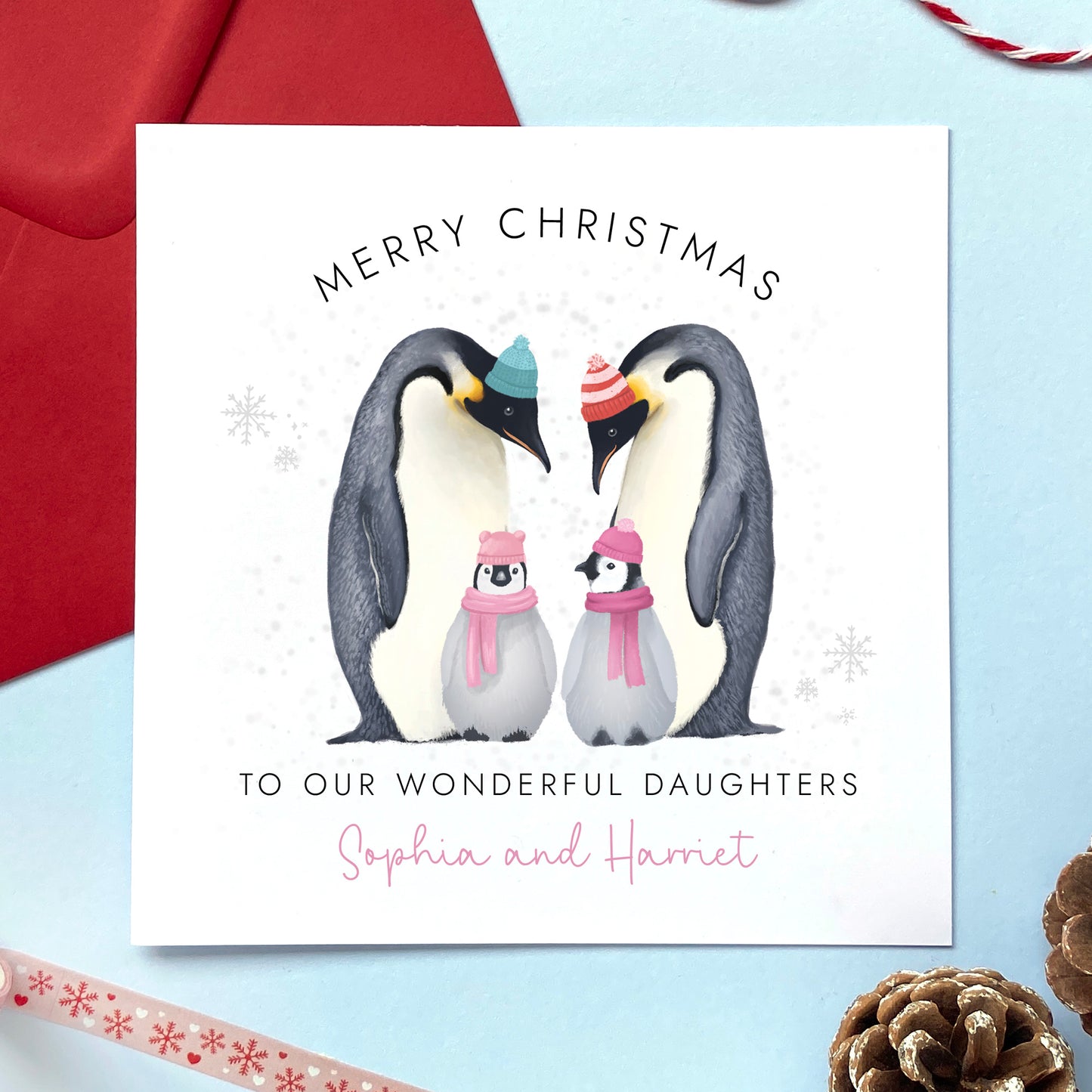 A personalised Christmas Card for Daughters. It features two parent parents and two baby penguins to represent two girls, children, babies or twins. It can be personalised with their names.