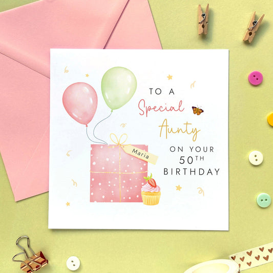 A special personalised birthday card for Auntie, featuring a pink present, pink and green balloons, and a strawberry cupcake. It's suitable for any Aunt, Aunty or Great Auntie. The age can be changed to any number, such as 18th, 21st, 30th, 40th and 50th.The card in the photo is for 50th birthday.