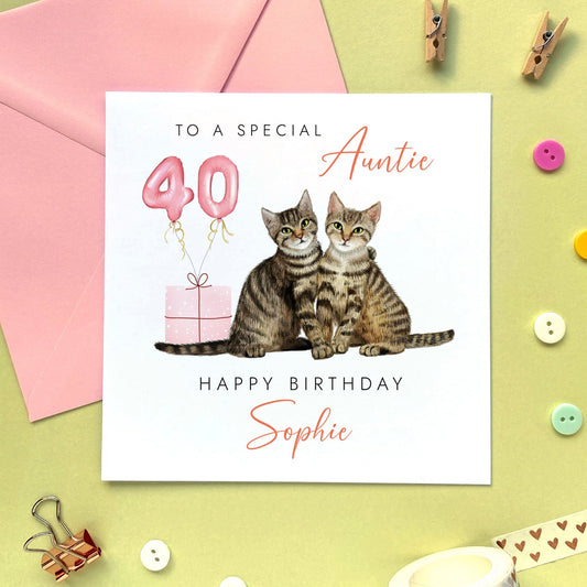 A cute personalised birthday card for Auntie featuring two tabby cats sitting next to each other. It's suitable for any Aunt, Aunty or Great Auntie. It can be personalised with any name. The age can be changed to any number such as 30th, 40th, 50th, 60th and 70th. The card in the photo is for 40th birthday.