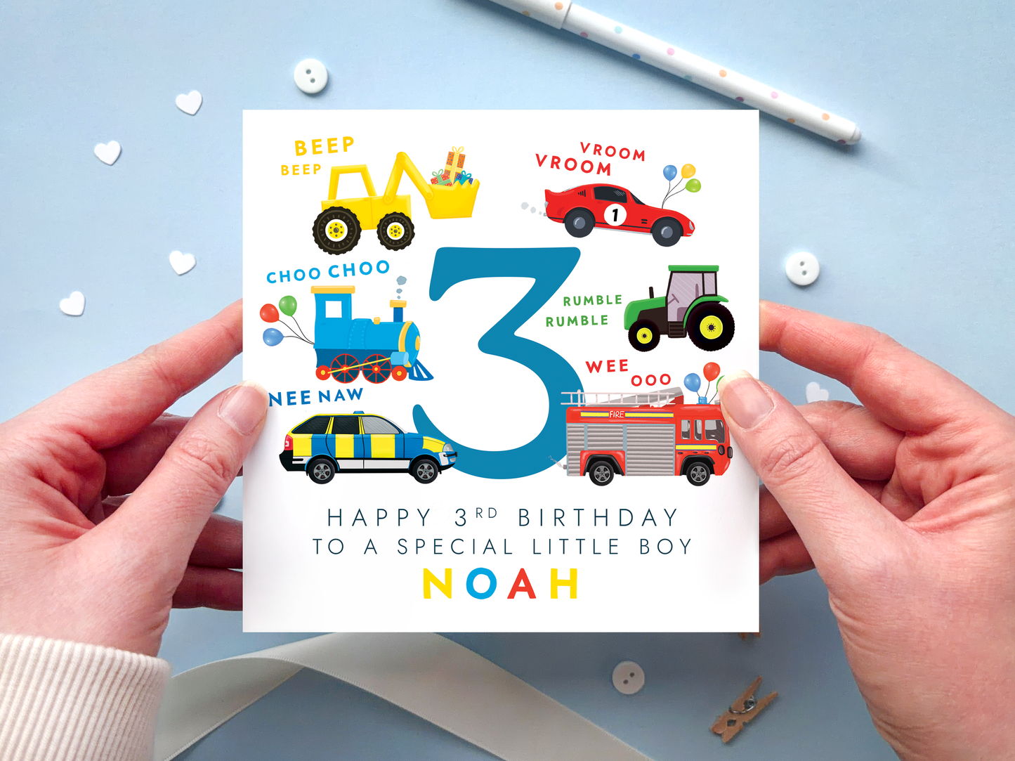 personalised transportation themed 3rd birthday card featuring colourful vehicles: yellow digger, red race car, blue train, green tractor, police car and fire engine around the number 3