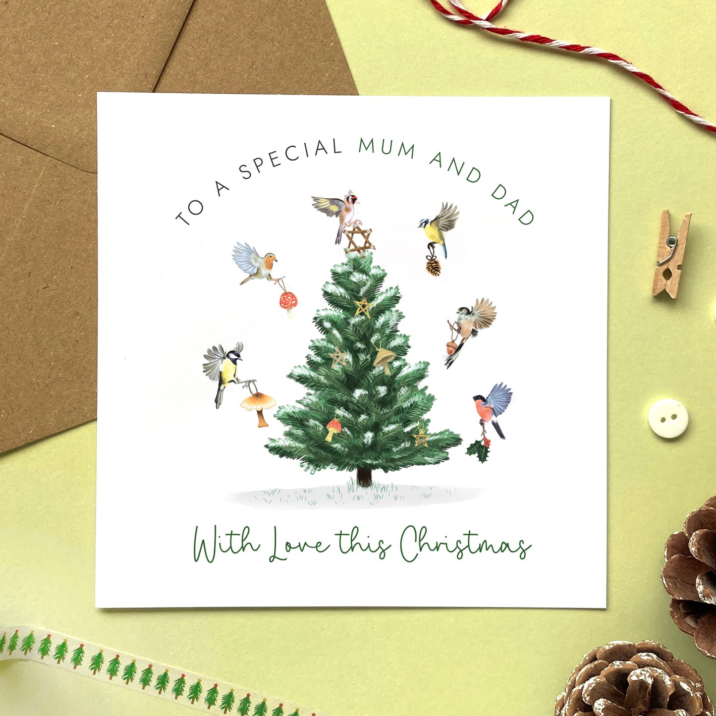 A personalised Woodland Birds Christmas Card for Mum and Dad. The card design has a variety of british garden birds decorating a tree.