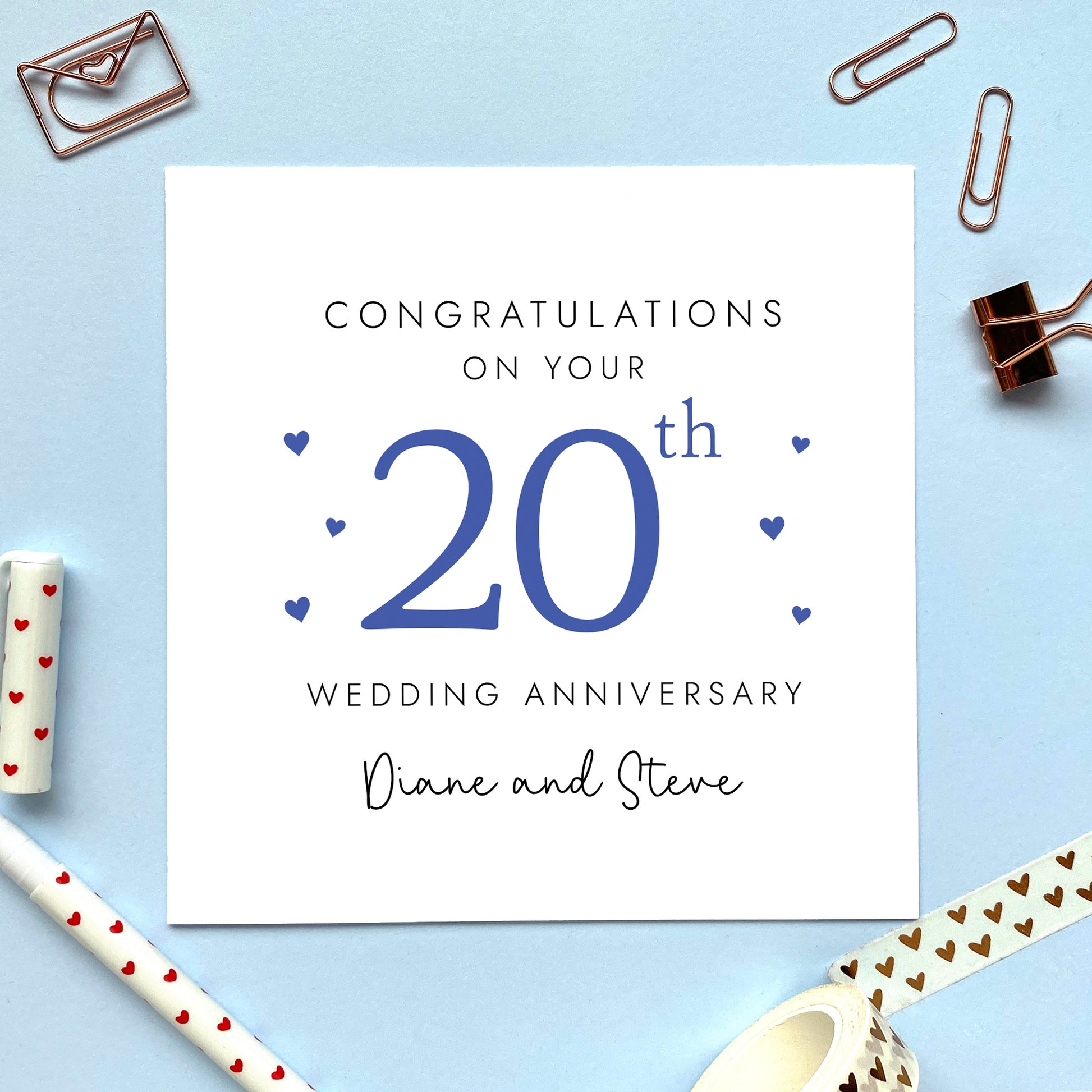 A personalised 20th wedding anniversary card for couple. It features '20th' in navy blue with blue hearts, the colour scheme matches the theme of china. The text reads 'Congratulations on your 20th wedding anniversary'. This card can be personalised with two names, and is suitable for special friends and family relations such as Daughter and Son-in-Law and Son and Daughter-in-Law. It is also suitable for gay and lesbian couples.