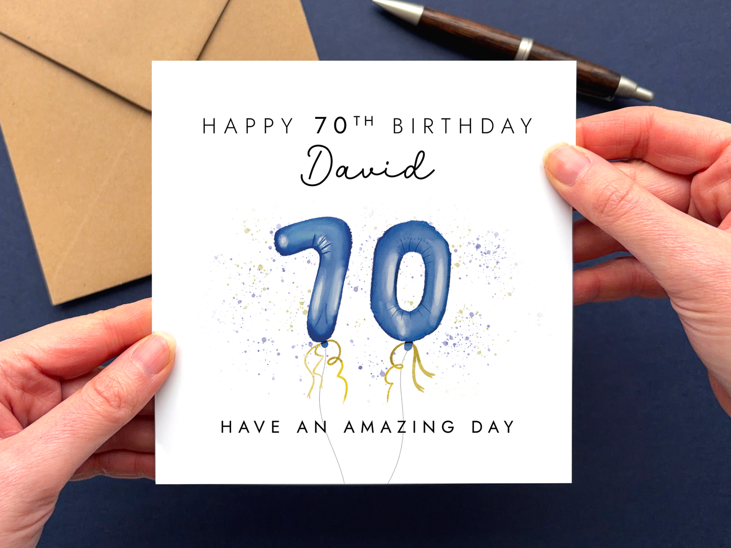 A personalised 70th birthday card for men featuring navy 70 balloons and the wording 'Happy 70th Birthday' and 'Have an amazing day'. It can be personalised with any man's name.