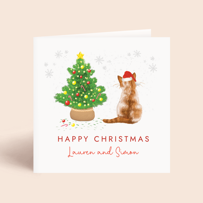 Personalised Cat Christmas card with a ginger and white tabby cat and decorated tree on a beige background