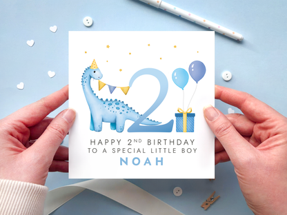 personalised dinosaur 2nd birthday card for special little boy with blue dinosaur next to the number 2