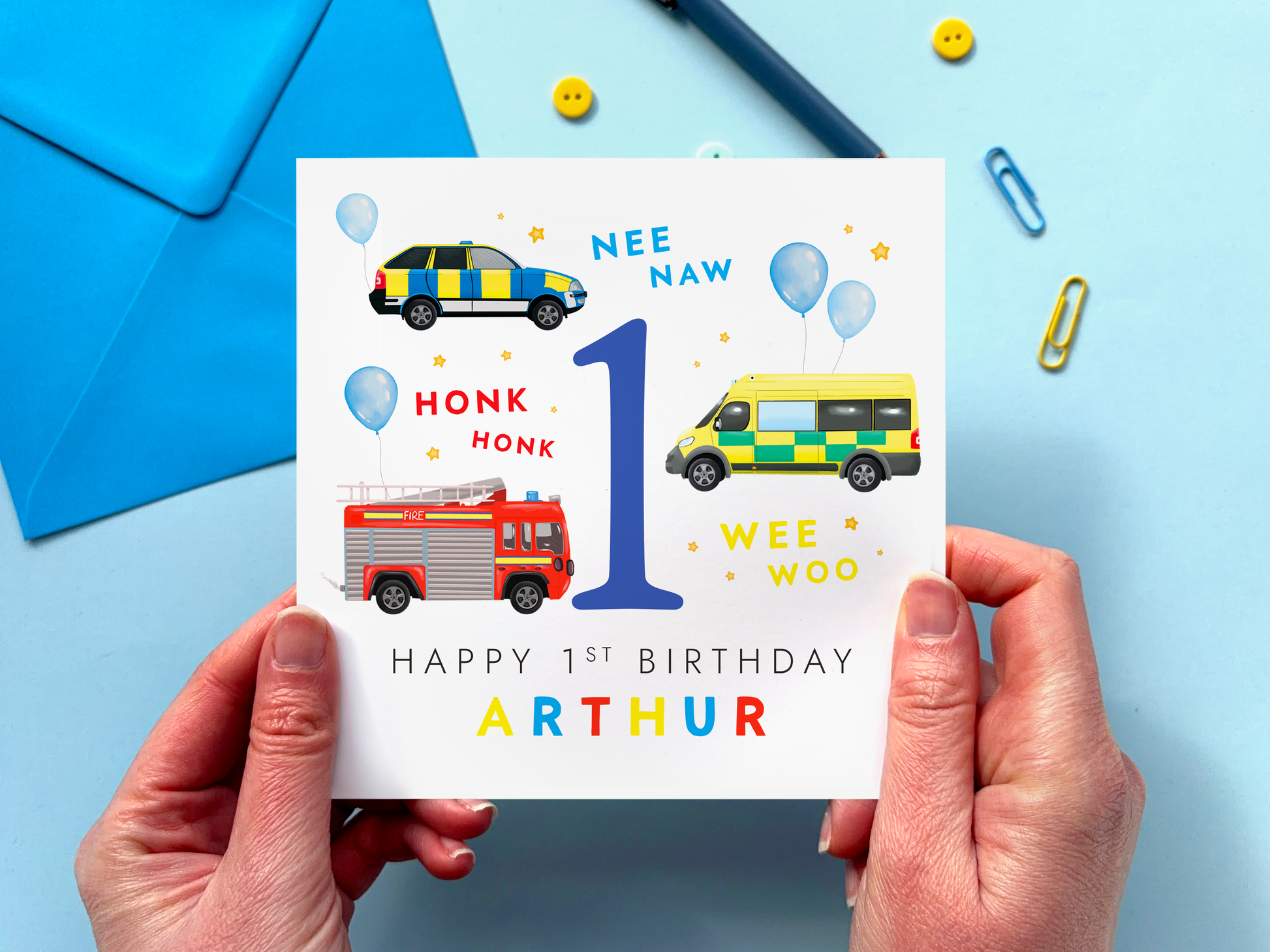 personalised emergency services 1st birthday card for boy featuring colourful emergency vehicles: a police car, ambulance and fire engine, around the number 1