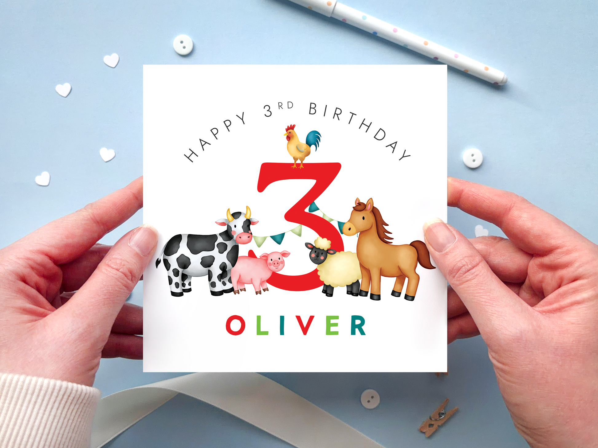 A bold and bright farm themed 3rd birthday card for boys. It features a sheep, pig, cow, horse and chicken, around the number three. It can be personalised with the child's name.