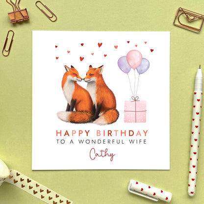 A personalised birthday card for her featuring a fox couple. It can be personalised with any relation, age and name. The card in the photo is a birthday card for Wife.