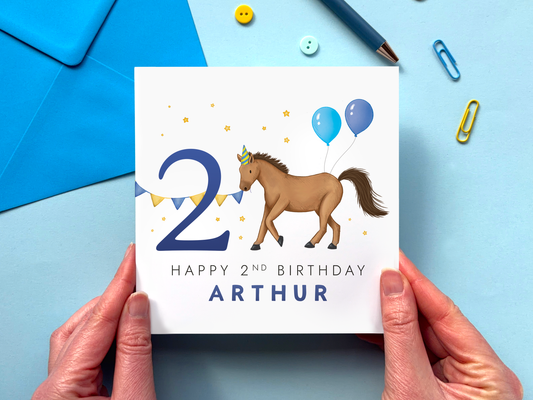 personalised 2nd horse birthday card for boys featuring a handdrawn design with a brown horse and the number 2, with blue balloons