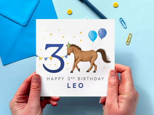 personalised 3rd horse birthday card for boys featuring a handdrawn design with a brown horse and the number 3, with blue balloons