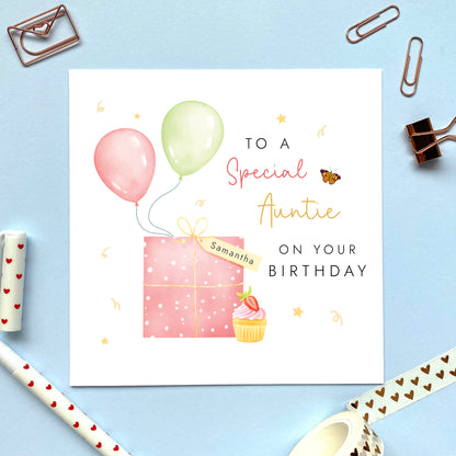 A special personalised birthday card for Auntie, featuring a pink present, pink and green balloons, and a strawberry cupcake. It's suitable for any Aunt, Aunty or Great Auntie. The age can be changed to any number, such as 18th, 21st, 30th, 40th and 50th.