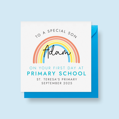 Personalised 1st day at primary school card for son. It features a bright rainbow with a blue theme. It can be personalised with any boy's name, school name and starting date.