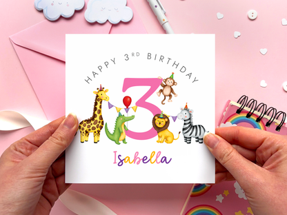 A personalised safari themed 3rd birthday card for girls, featuring illustrations of jungle animals - giraffe, crocodile, lion, zebra and monkey - around the number 3, in bright and bold colours