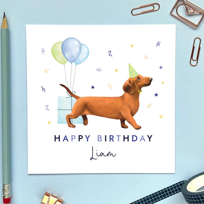 A personalised dog birthday card for him featuring a sausage dog (Dachshund). It can be personalised with any name and age.