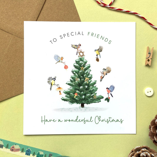 A personalised Christmas Card for Friends. It features a variety of british garden birds decorating a fir tree.